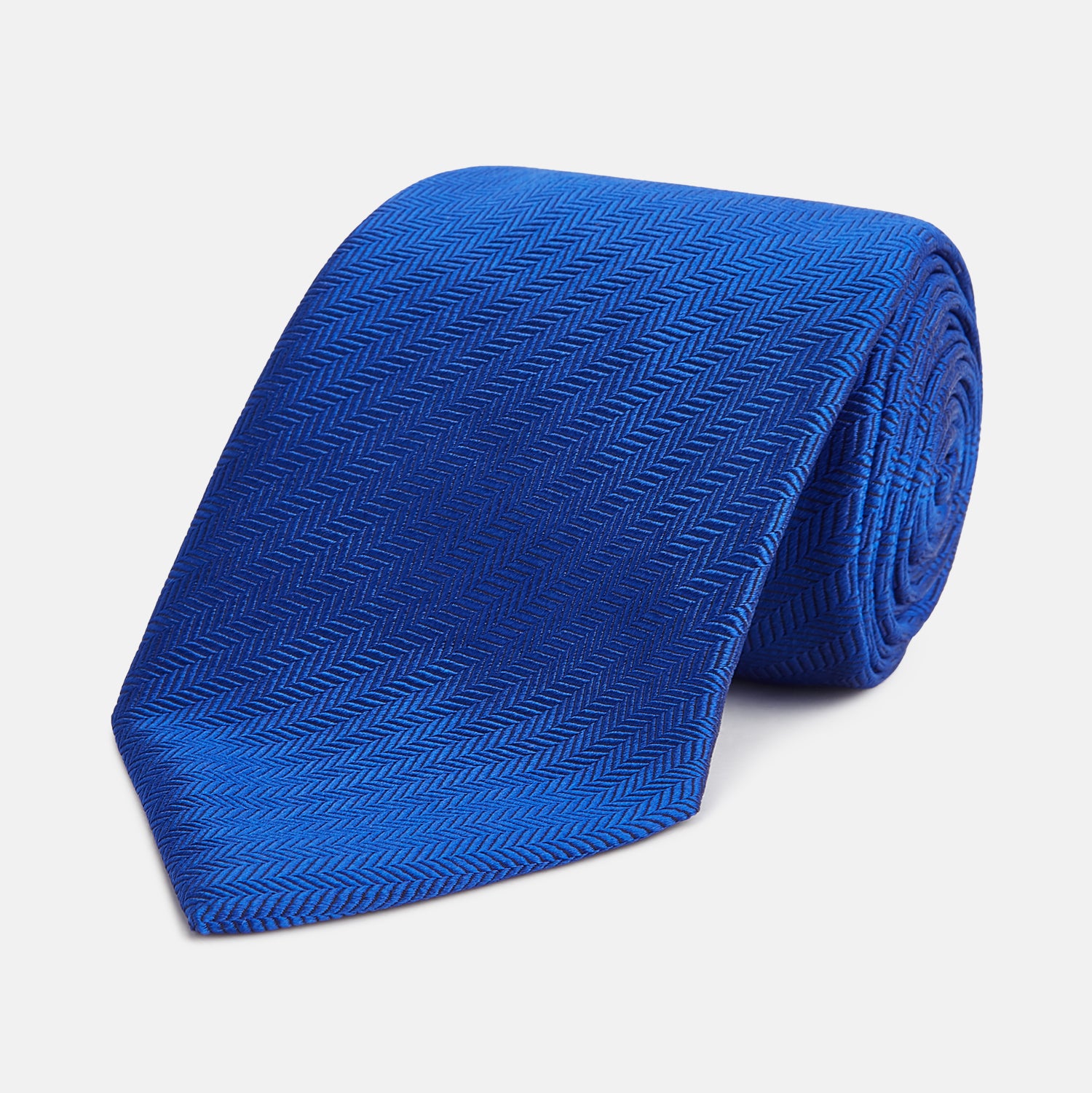 View 1 of product The Turnbull & Asser Plain Herringbone Cruise Tie in bright blue, shown rolled up on a white background, features a subtle chevron pattern—an essential finishing touch for your smart look.