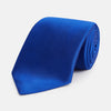 View 1 of product The Turnbull & Asser SATIN CRUISE TIE, in vibrant royal blue with a smooth, lustrous finish, creates a striking contrast against a plain white background.