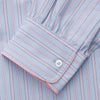 View 3 of product The Blue and Pink Stripe Poplin Cotton Nightshirt by Turnbull & Asser features long sleeves, a collar, front buttons, chest pocket, rounded hem, and light blue fabric with white, pink, and yellow vertical stripes.