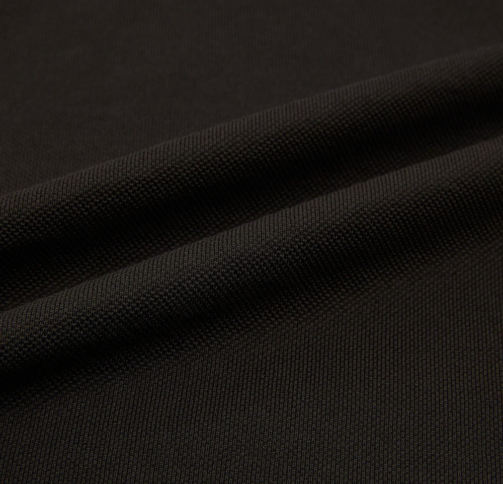 A brown cotton jersey polo shirt by Turnbull & Asser with short sleeves, a collar, three buttons, and a buttoned chest pocket, laid flat on a white background.