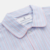 View 2 of product The Blue and Pink Stripe Poplin Cotton Nightshirt by Turnbull & Asser features long sleeves, a collar, front buttons, chest pocket, rounded hem, and light blue fabric with white, pink, and yellow vertical stripes.