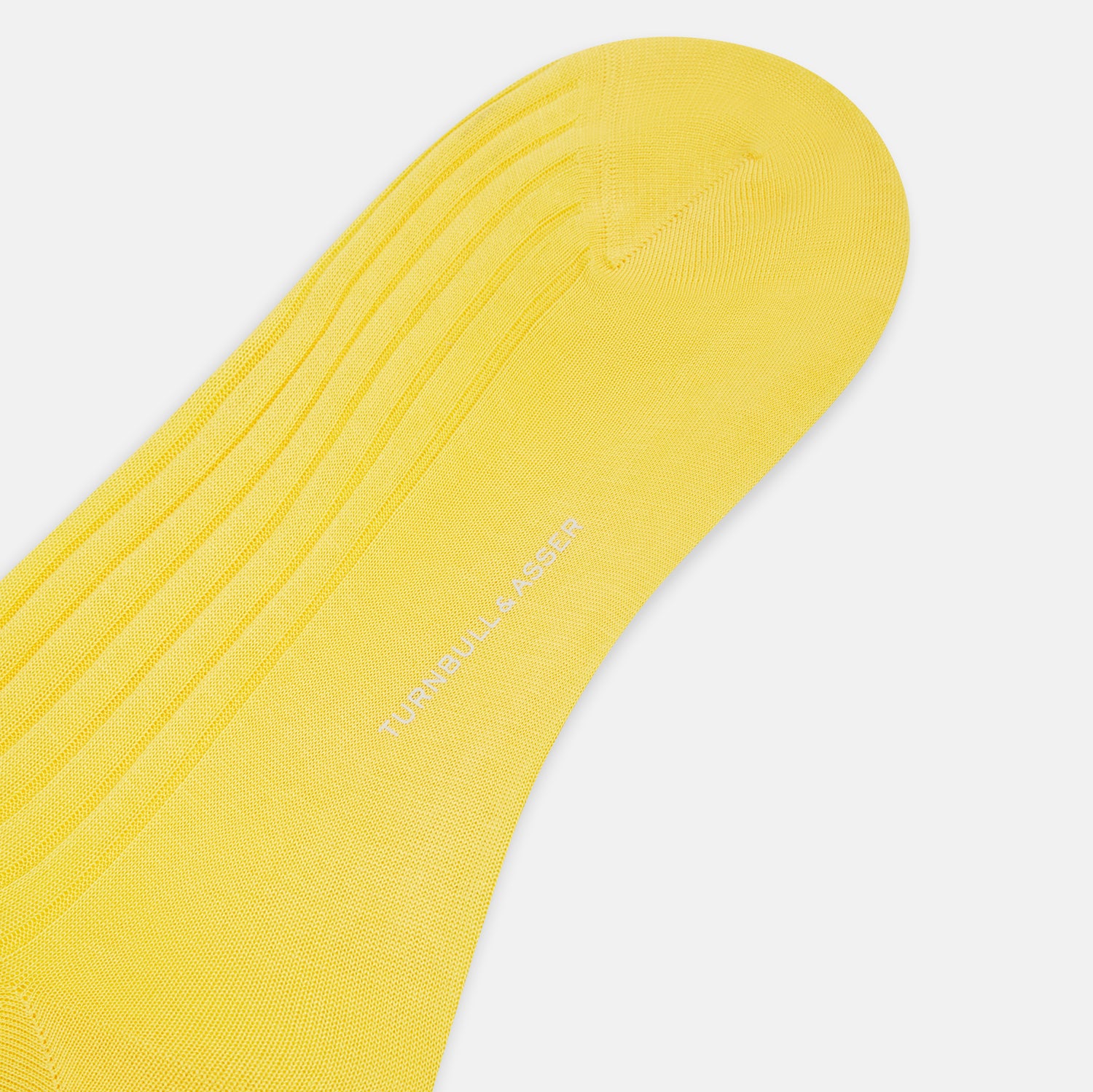 View 3 of product A single Chartreuse Lemon Long Sock by Turnbull & Asser, knee-high with a ribbed texture and made from luxurious Egyptian cotton, is displayed against a plain white background.