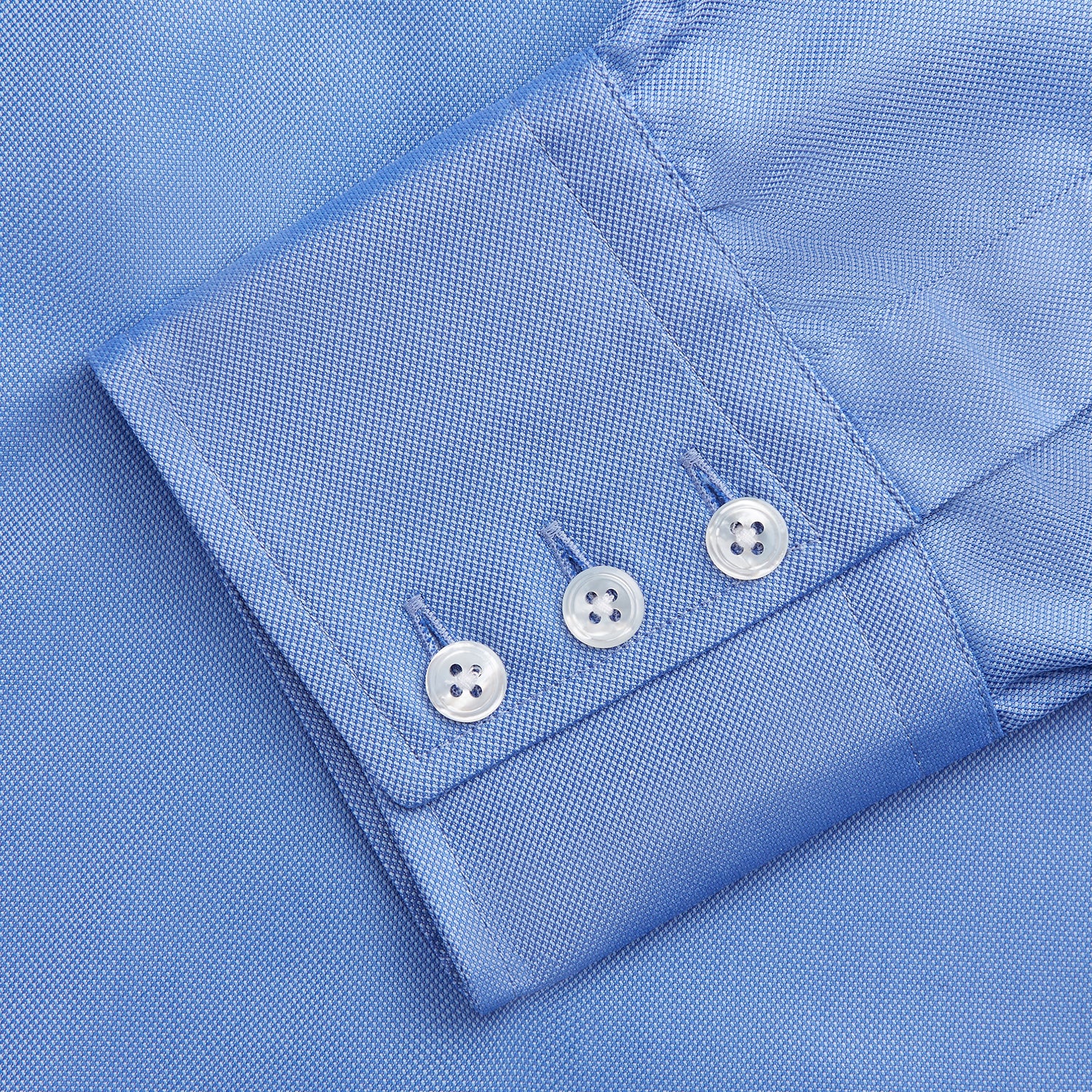 View 5 of product The Turnbull & Asser "The World Is Not Enough" blue cotton Istanbul shirt, as seen on James Bond, is a light blue oxford long-sleeve button-up with a pointed collar and white buttons, displayed on a white background.