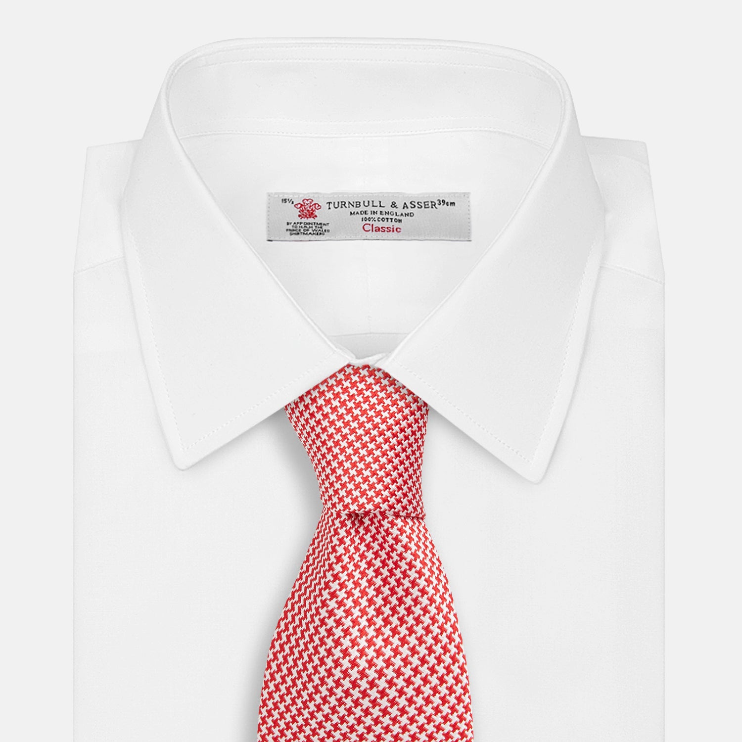 View 2 of product The HOUNDSTOOTH WHITE TULIP RED TIE by Turnbull & Asser features a refined red and white houndstooth pattern—an elegant accessory that elevates any crisp shirt or formal look.