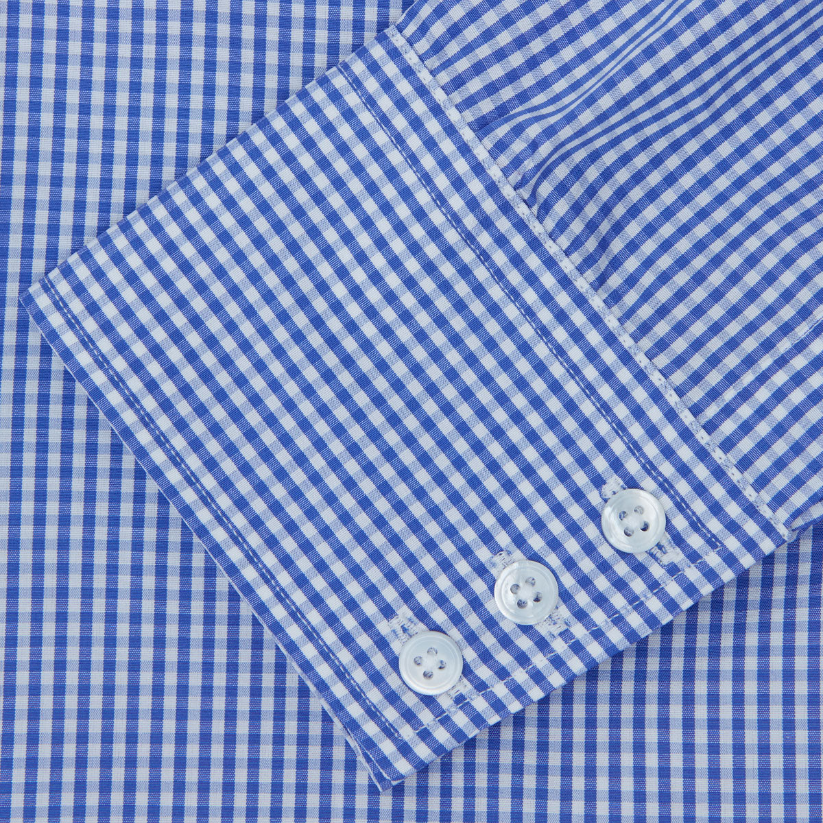 View 3 of product The Turnbull & Asser Mid-Blue Gingham Check Shirt features a T&A collar and 3-button cuffs, crafted from cotton and displayed folded on a plain white background.