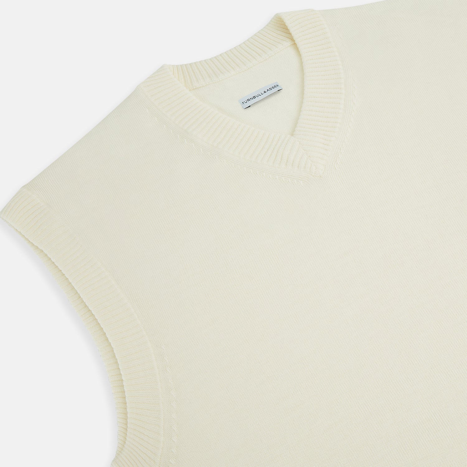 View 2 of product The Turnbull & Asser Cream Fine Merino V-Neck Vest is a sleeveless knit with ribbed edges, ideal for a refined modern look. Shown on a plain white background.