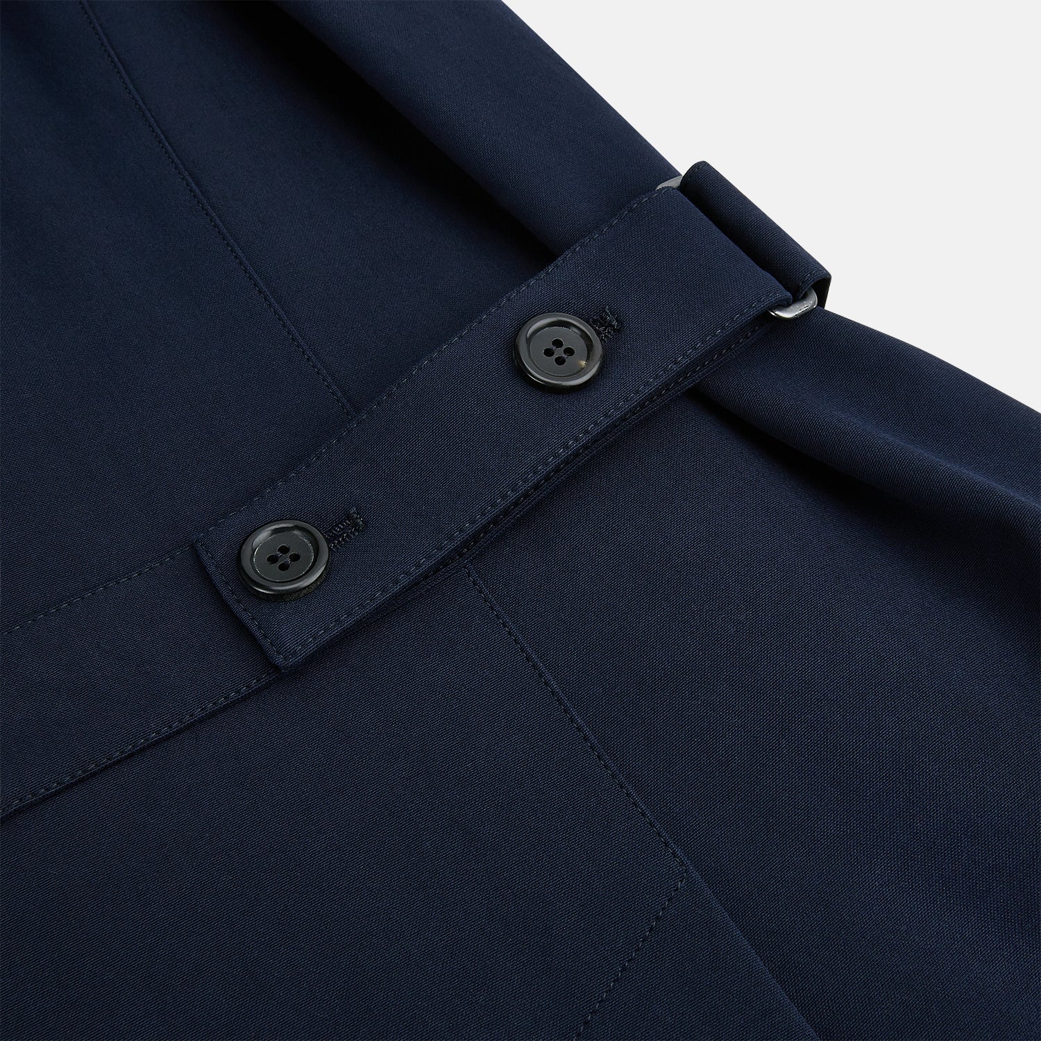 View 5 of product A Navy John Arthur Trench Coat by Turnbull & Asser, featuring a collar, button closure, adjustable cuff straps, two slanted front pockets, and a chest zip pocket, is displayed flat on a white background.