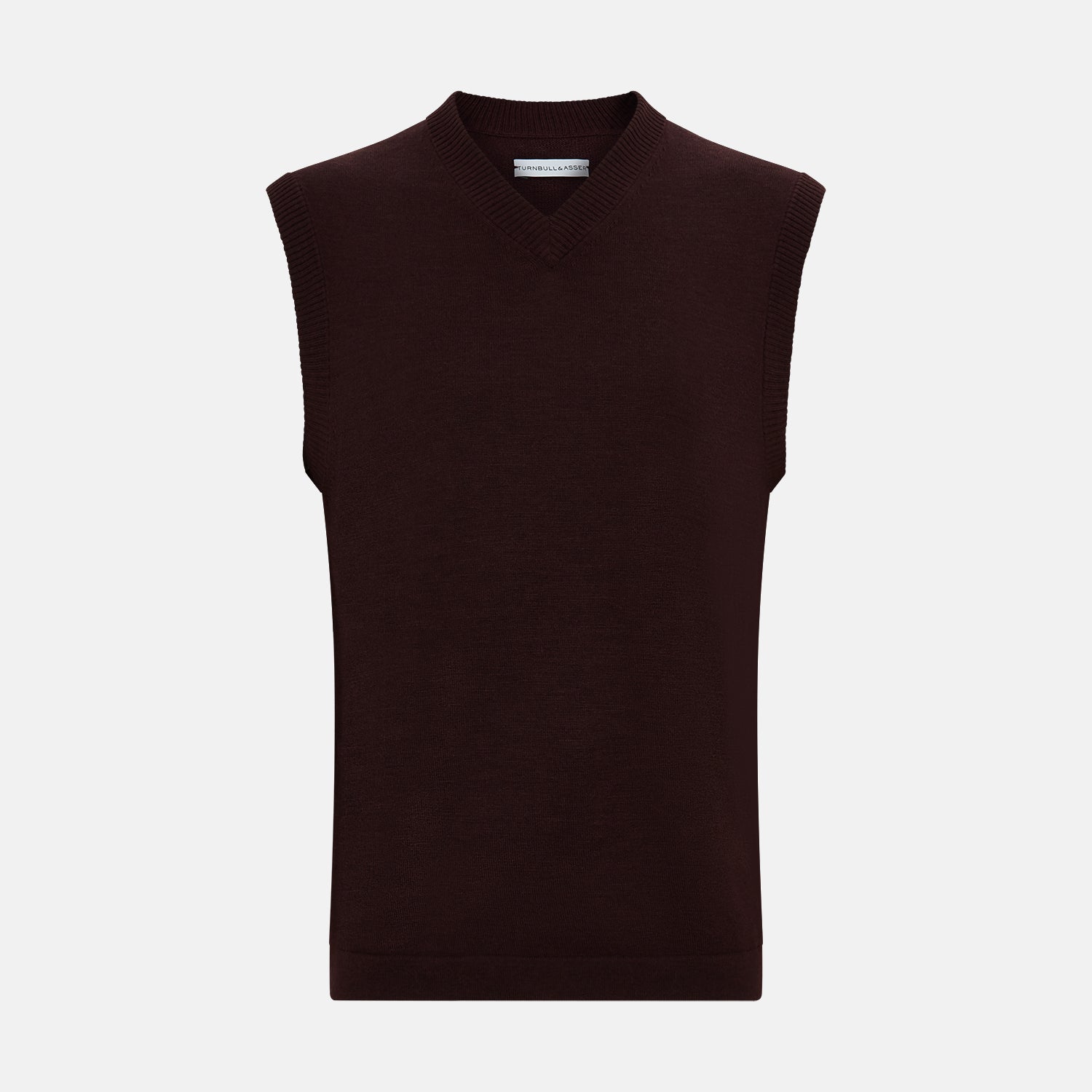 View 1 of product The Turnbull & Asser Burgundy Fine Merino V-Neck Vest is a sleeveless knitwear piece with ribbed trim at the neck, armholes, and hem, shown against a plain white background.
