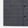 View 7 of product The Turnbull & Asser Charcoal Melange Check Hampstead overshirt, a long-sleeve button-up with a collar and two zippered side pockets, is laid flat on a light gray background.
