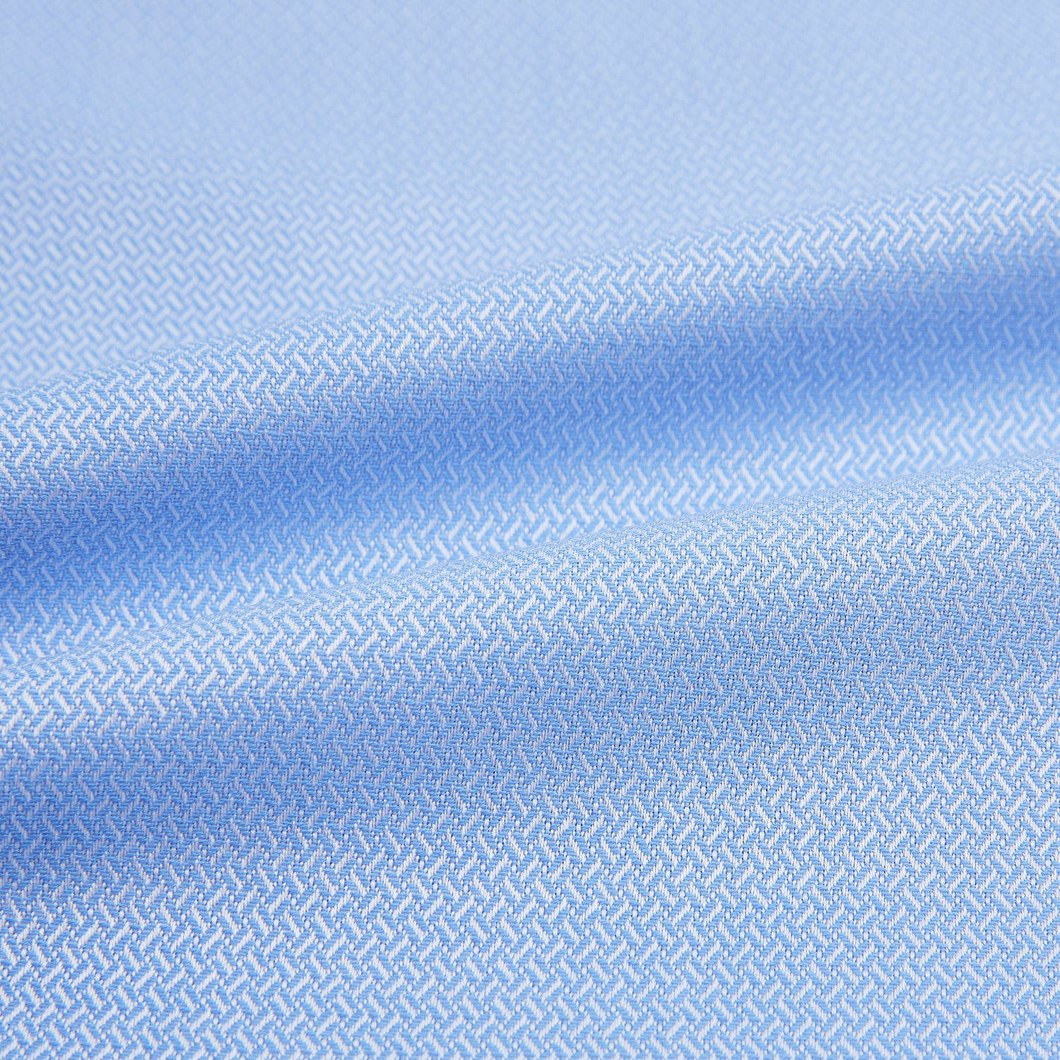 View 6 of product The Blue Herringbone Mayfair Shirt by Turnbull & Asser features light blue and white stripes, long sleeves, a classic collar, white buttons, and buttoned cuffs. Shown on a plain white background, it's perfect for formal occasions.