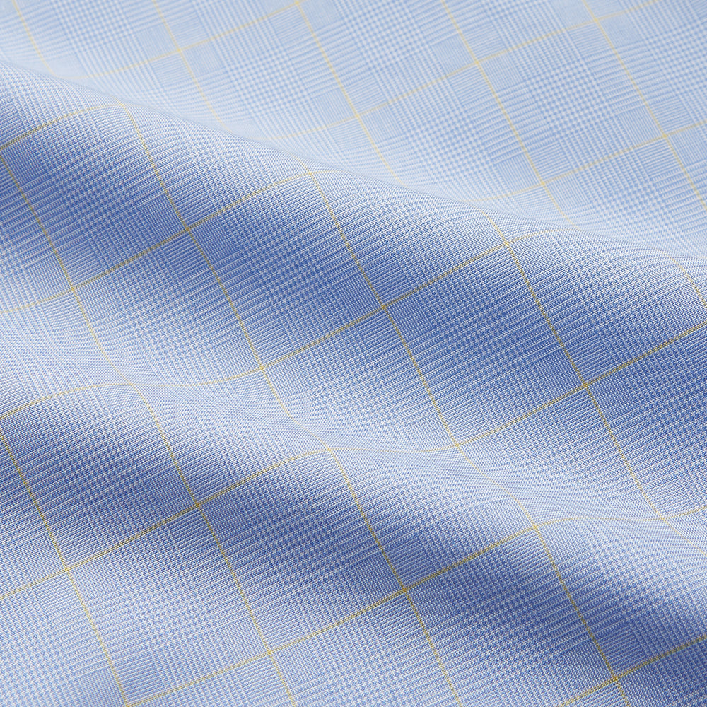 The Yellow and Blue Prince of Wales Check Belgravia Shirt by Turnbull & Asser features a classic collar, white buttons, long sleeves, and a checked pattern, displayed laid flat on a white background.