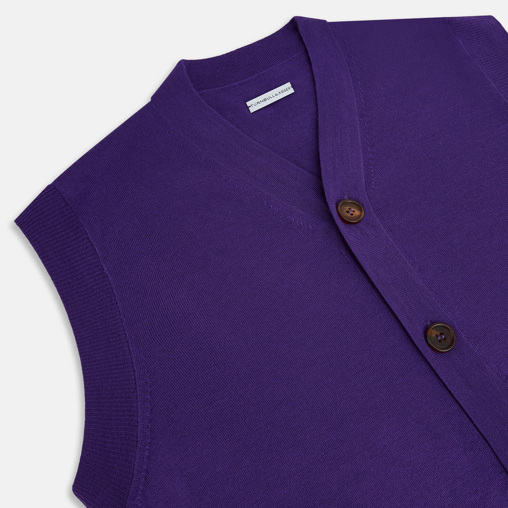 The Turnbull & Asser Purple Fine Merino V-Neck Sleeveless Cardigan features a button-up front and two pockets, displayed against a plain white background.