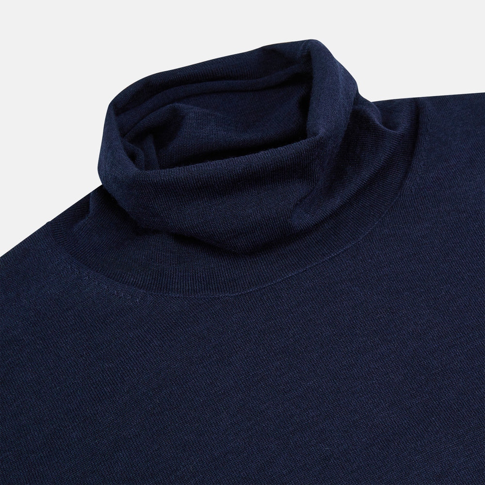 The Turnbull & Asser Navy Fine Merino High Neck Jumper, a plain long-sleeved piece crafted from premium merino wool, is shown on a white background.