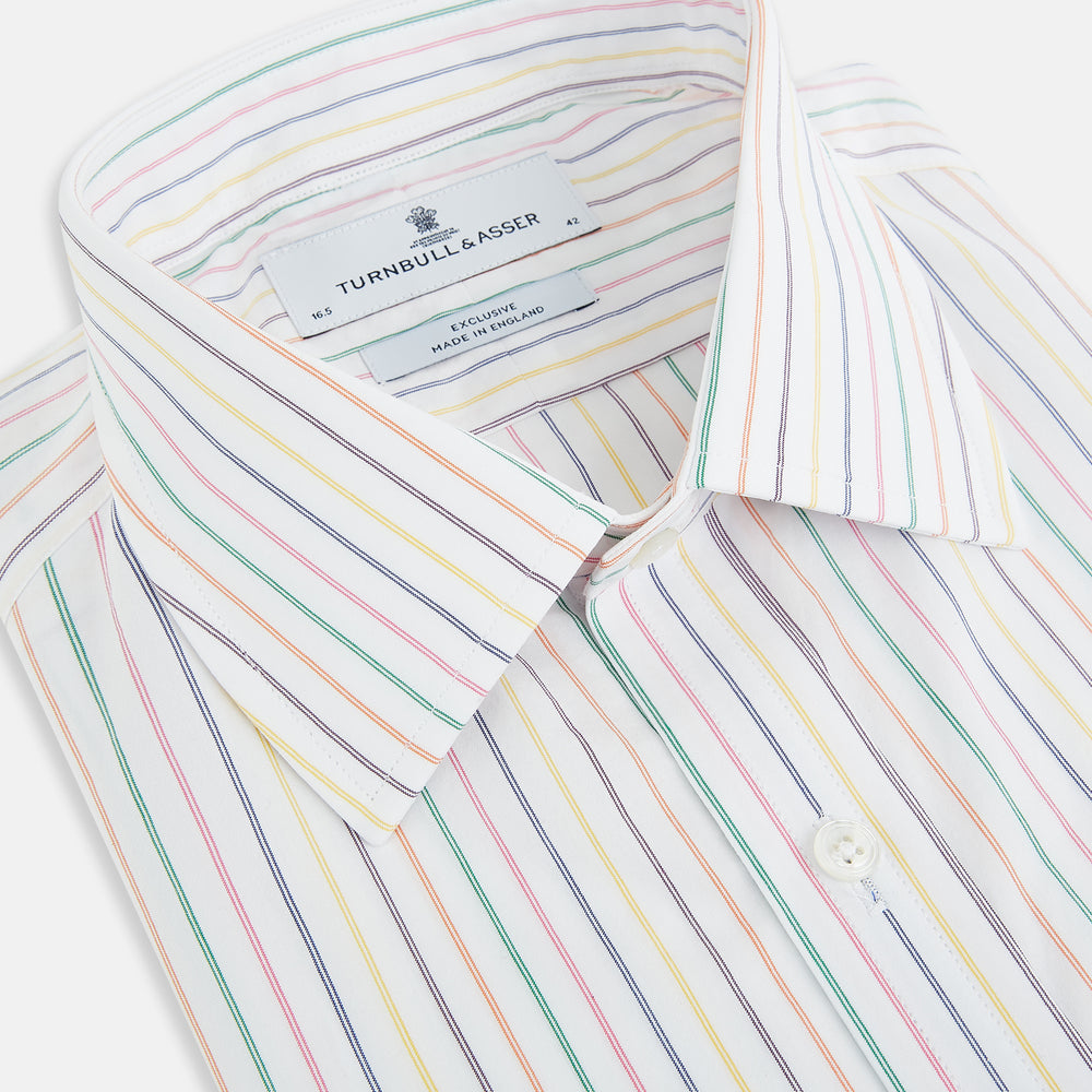 The Turnbull & Asser Rainbow Double Pinstripe Mayfair Shirt is a pure cotton, long-sleeved button-up with a collar and buttoned cuffs, featuring colourful blue, red, and yellow stripes on white, displayed on a plain white background.