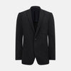 View 1 of product The Turnbull & Asser Charcoal Knitted Oxford Blazer features a notched lapel, two-button closure, and three front pockets, blending modern elegance with British heritage against a plain white background.
