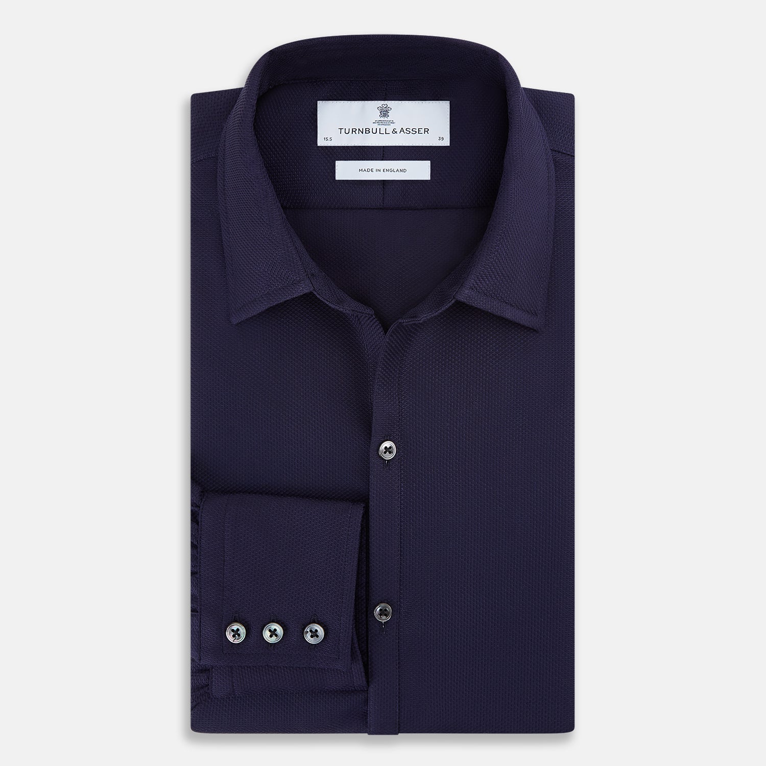 View 5 of product The Navy Textured Windsor Shirt by Turnbull & Asser features long sleeves, a Windsor collar, buttoned cuffs, and white buttons—a fine example of British craftsmanship—set against a plain white background.