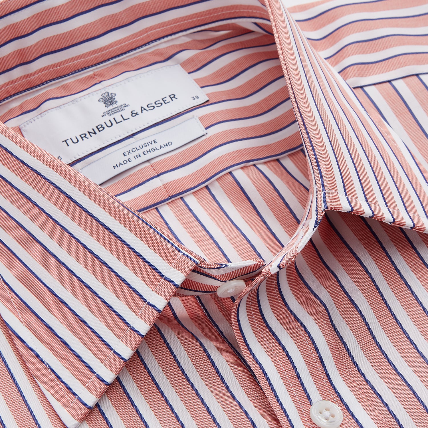 View 4 of product The Turnbull & Asser Orange and White Stripe Cotton Regular Fit Mayfair Shirt features vertical stripes, a classic collar, and buttoned cuffs—an essential men’s wardrobe piece, shown laid flat on a white background.