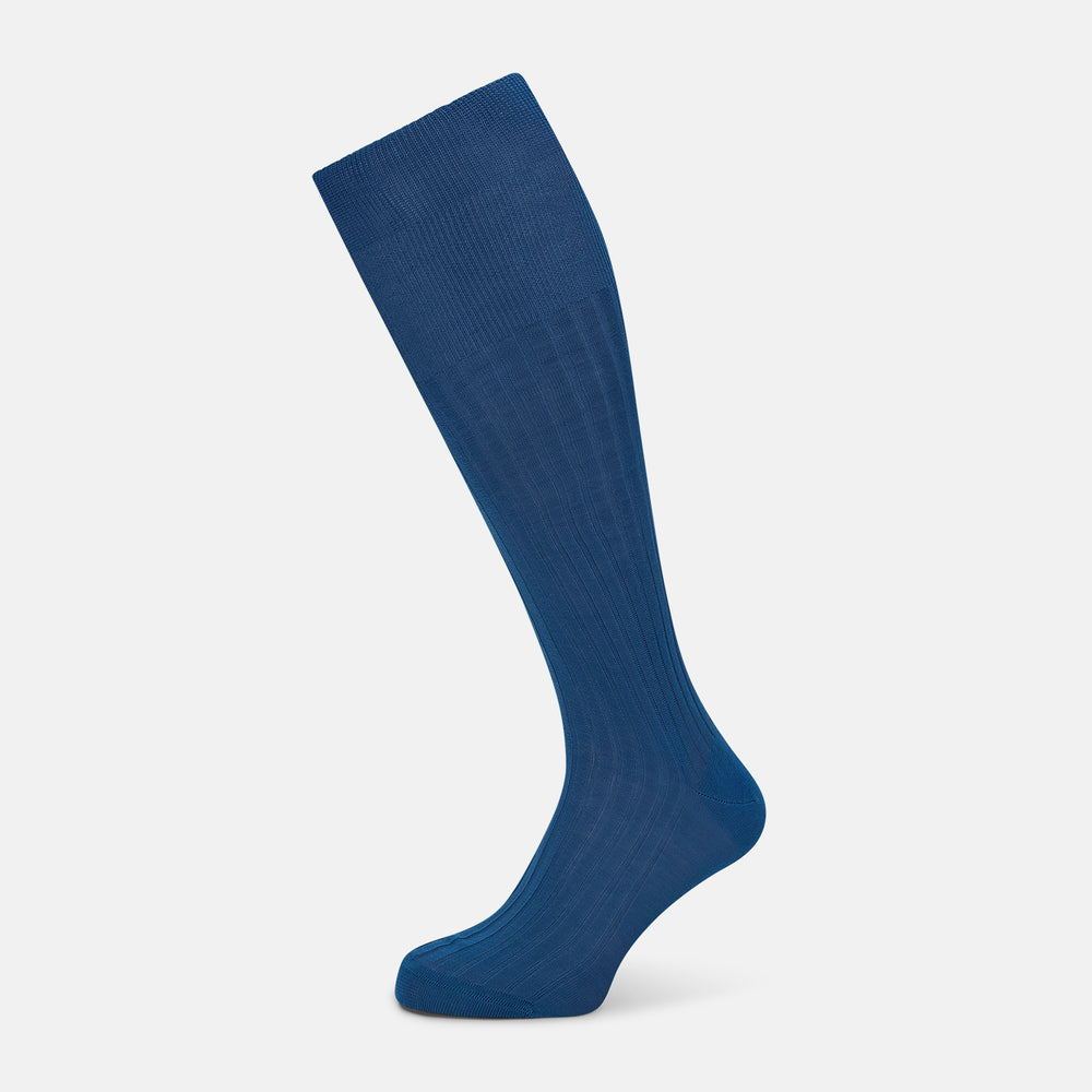 A single Azzurro Long Sock by Turnbull & Asser, in blue mercerised Egyptian cotton with a ribbed texture, is shown upright and angled left against a plain light background.