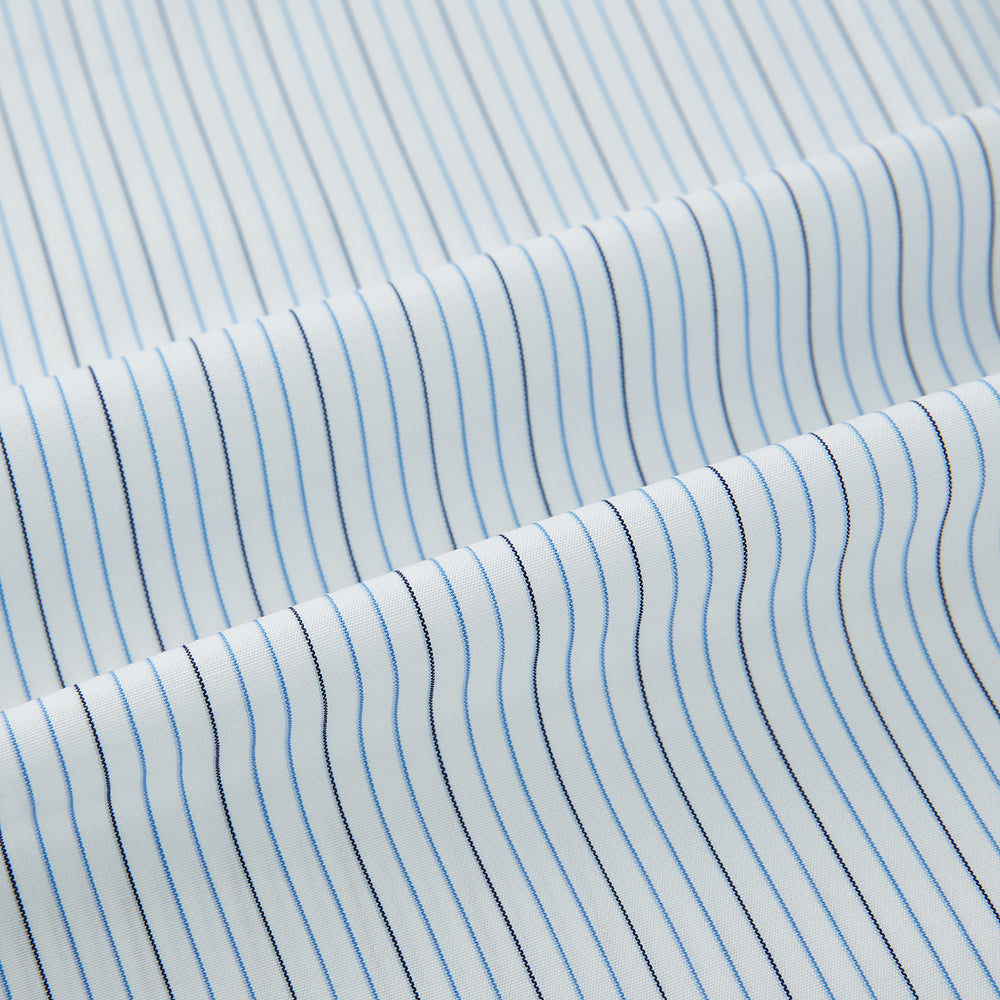 The Turnbull & Asser Pale Blue and Navy Pinstripe Westminster Shirt features long sleeves, a classic collar, and buttoned cuffs, highlighting British craftsmanship. The shirt is laid flat on a white background.