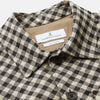 View 2 of product The Turnbull & Asser Black Gingham Check Wool Blend Somerset Overshirt features long sleeves, two chest flap pockets with buttons, and a black-and-beige check pattern. Shown laid flat on a white background; ideal as transitional outerwear.