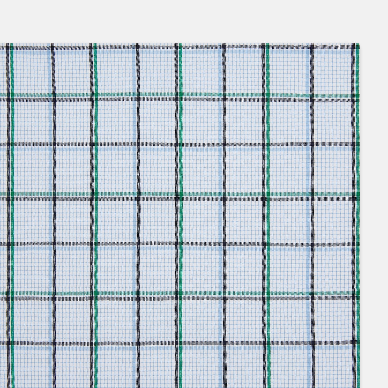 View 2 of product The Turnbull & Asser Hand Rolled Blue and Green Tattersall Check Handkerchief—a white cotton pocket square with blue, green, and black check pattern—is neatly displayed on a plain white background.
