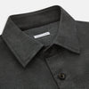 View 2 of product The Charcoal Melange Hampstead overshirt by Turnbull & Asser is a dark gray long-sleeve button-up with a collar, left chest pocket, and two zippered side pockets, shown laid flat on a white background.