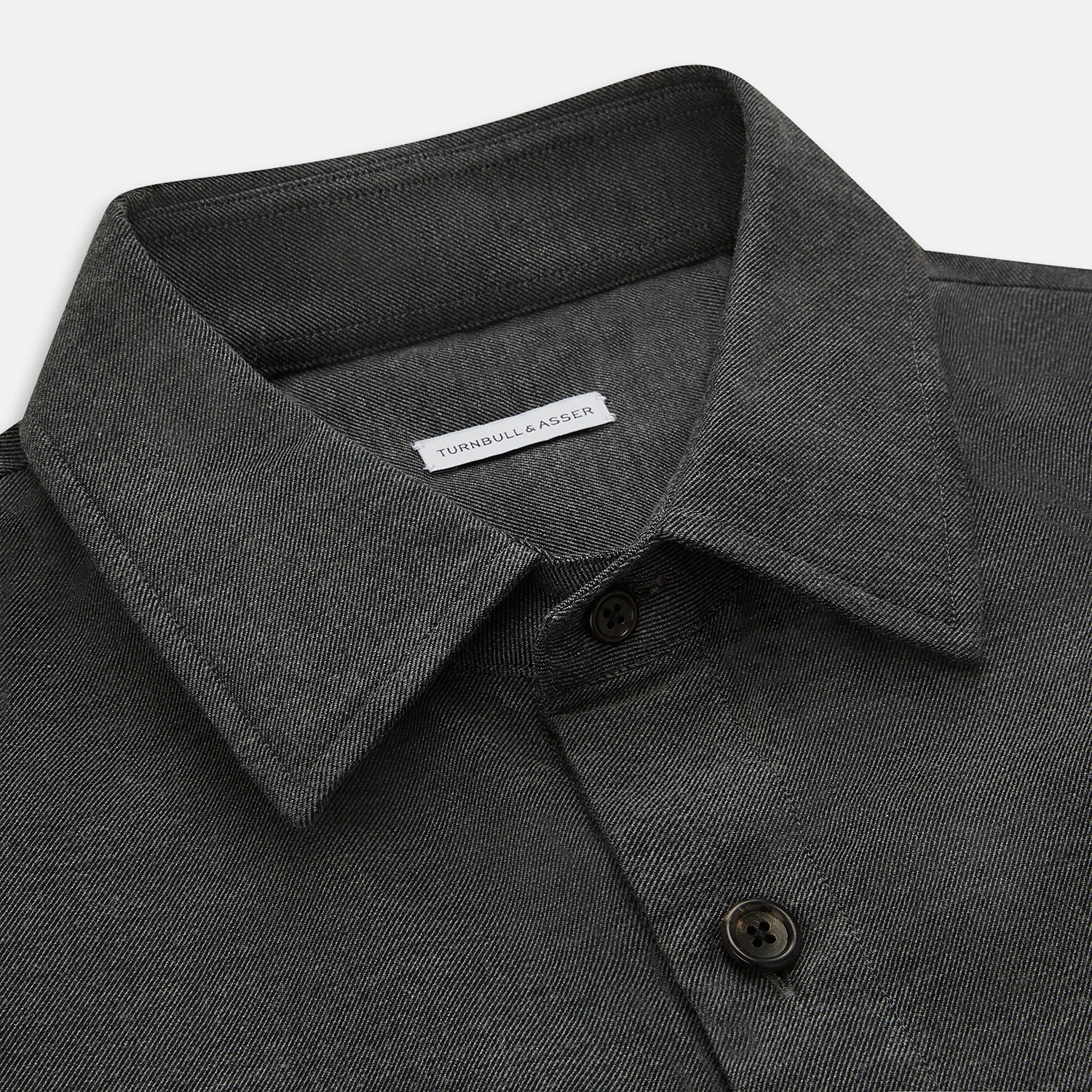 View 2 of product The Charcoal Melange Hampstead overshirt by Turnbull & Asser is a dark gray long-sleeve button-up with a collar, left chest pocket, and two zippered side pockets, shown laid flat on a white background.
