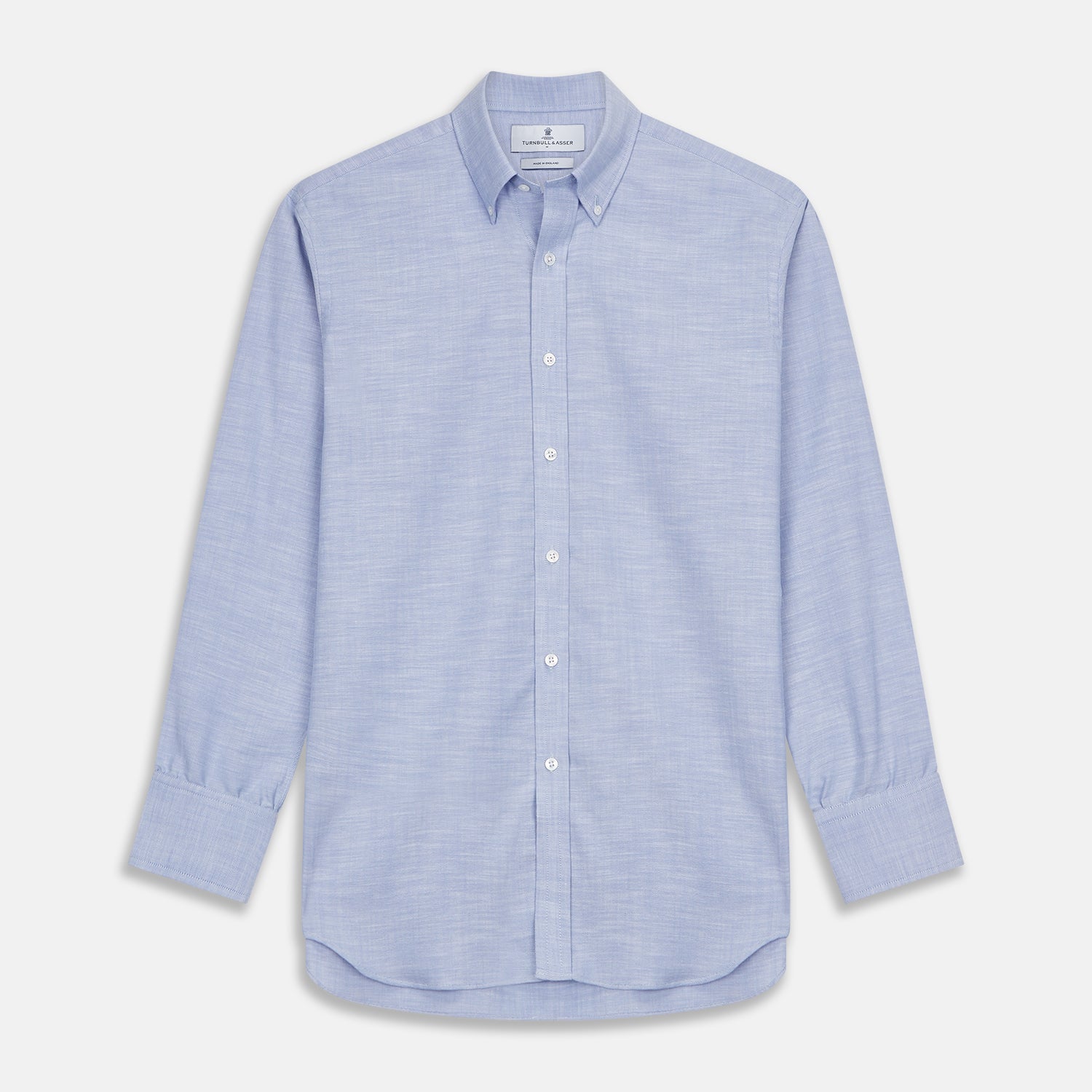 View 1 of product The Turnbull & Asser Mid-Blue Chambray Weekend Fit Shirt features a Dorset collar, white buttons, and 1-button cuffs. It is laid flat on a white background.