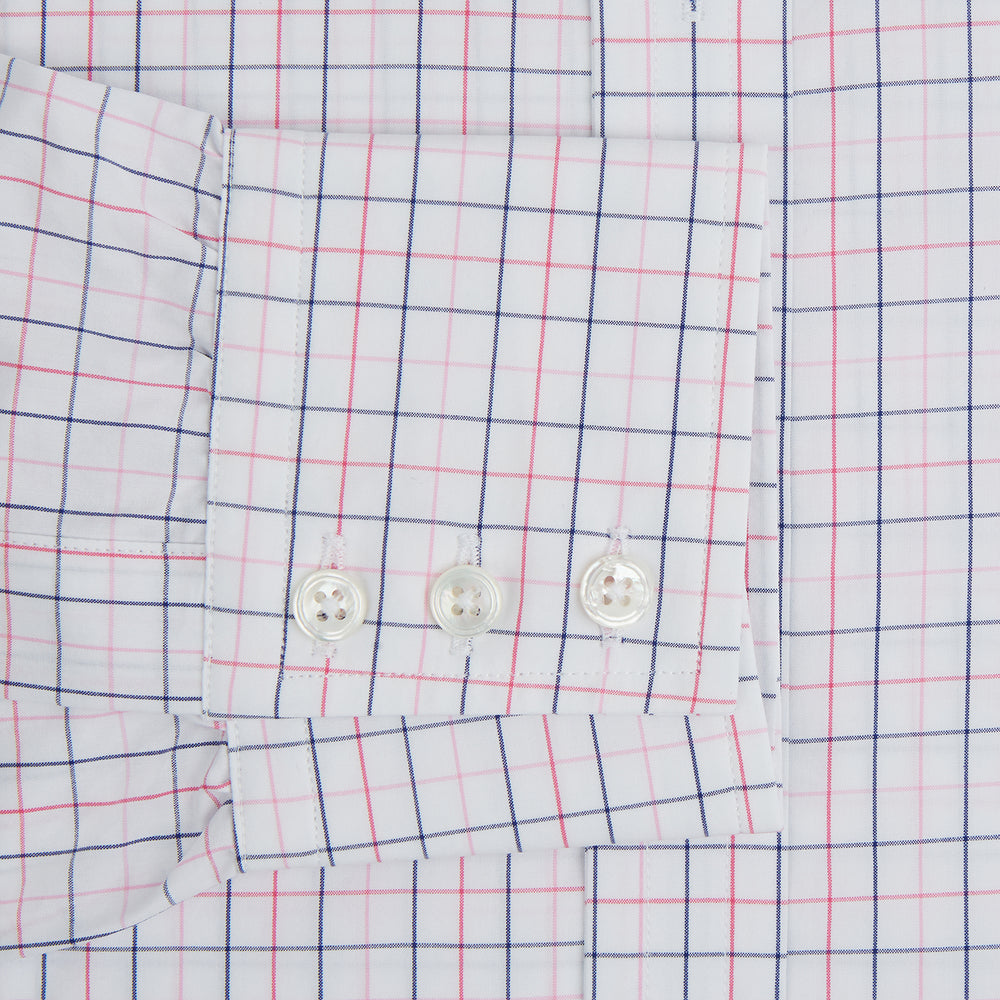 The Turnbull & Asser Pink Overlay Grid Check Mayfair Shirt is a long-sleeved, button-up with a collar and buttoned cuffs, featuring a white base and thin pink grid lines. Laid flat against a white surface.