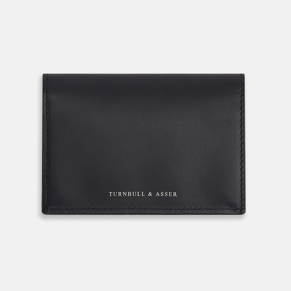 A navy full-grain leather bi-fold card holder with neat stitching and "Turnbull & Asser" embossed in white near the bottom center.