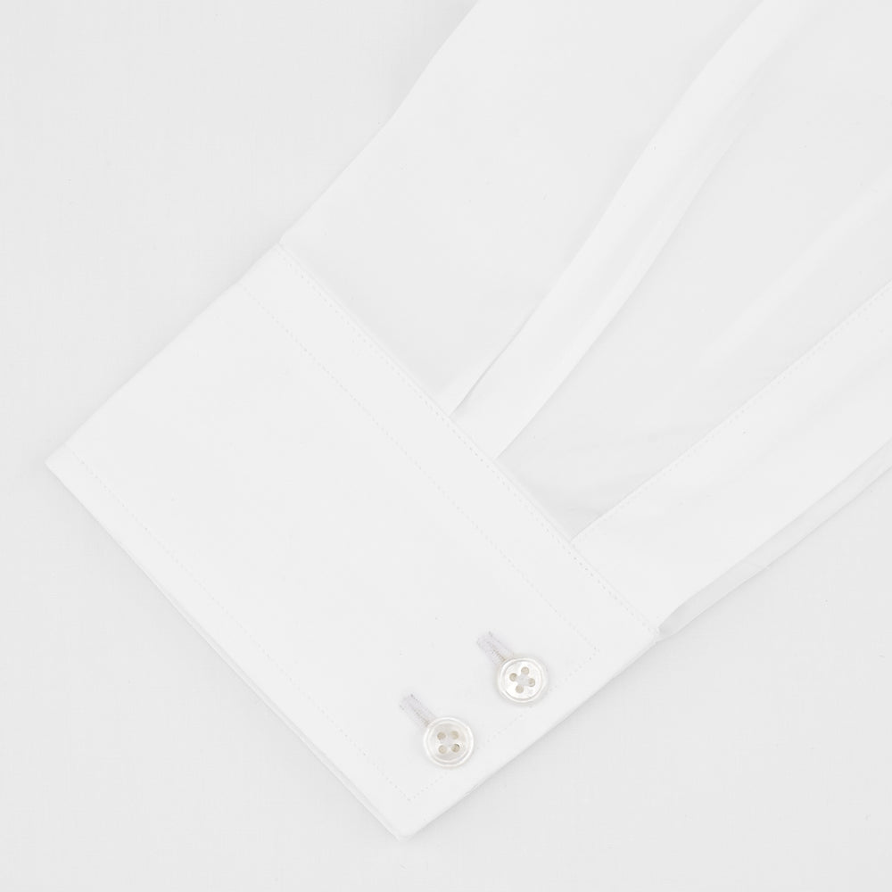 A Turnbull & Asser Tailored Fit Two-Fold 120 White Cotton Shirt with a Kent collar and 2-button cuffs is neatly folded against a light blue background, displaying the brand label inside the collar.