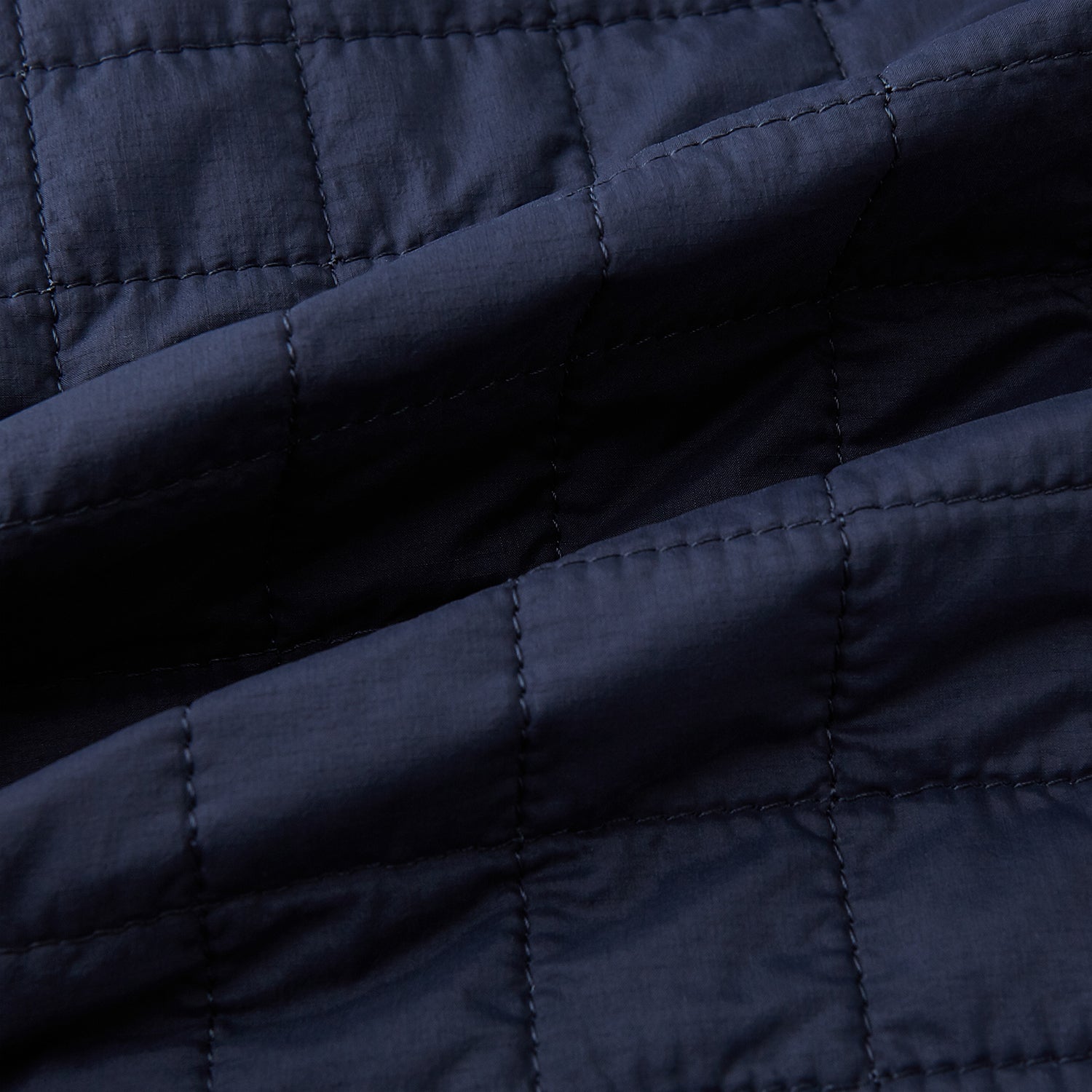 View 4 of product The Turnbull & Asser Navy Double-Breasted Quilted Gilet is a sleeveless piece with an asymmetrical button closure, chest pocket, and two zippered side pockets, shown on a plain white background—ideal for layered dressing.