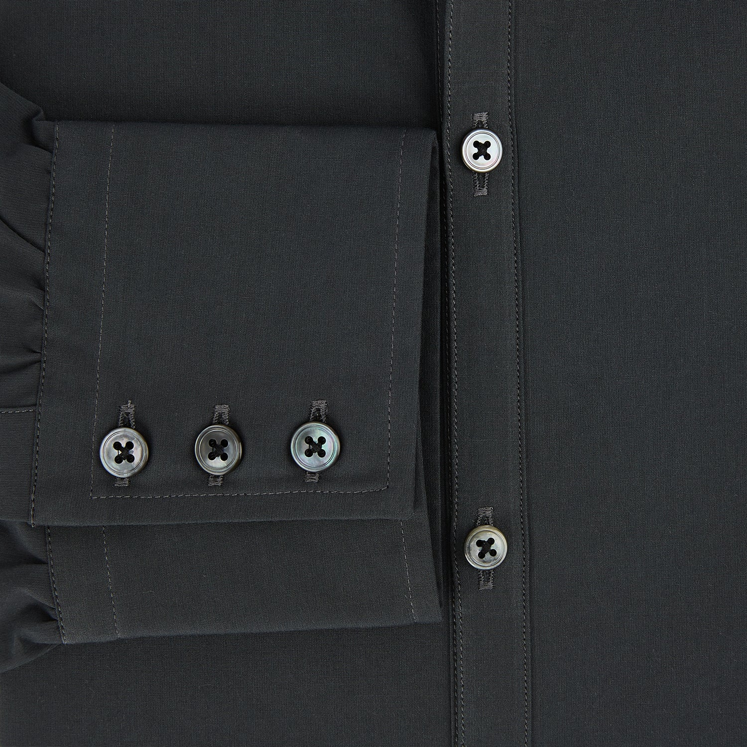 View 4 of product The Charcoal Windsor Shirt by Turnbull & Asser is a black, long-sleeve button-up with a pointed Windsor collar, buttoned cuffs, and a straight hem, shown flat on a white background.