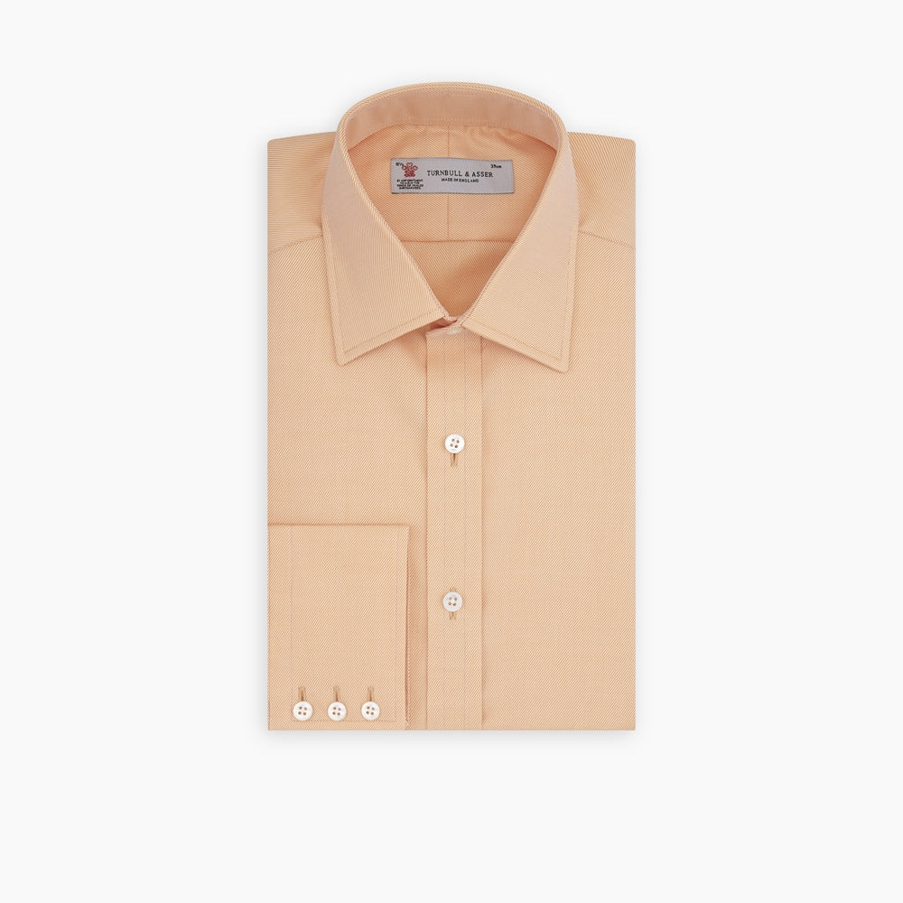 A neatly folded Orange Oxford Classic Fit Shirt with a T & A collar by Turnbull & Asser is displayed on a white background—a versatile piece for minimalist outfits or pairing with bold ties.