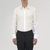 View 3 of product The Turnbull & Asser Tailored Fit Two-Fold 120 White Cotton Shirt features a Kent collar, double cuffs, and button-down front, displayed neatly folded against a light blue background.