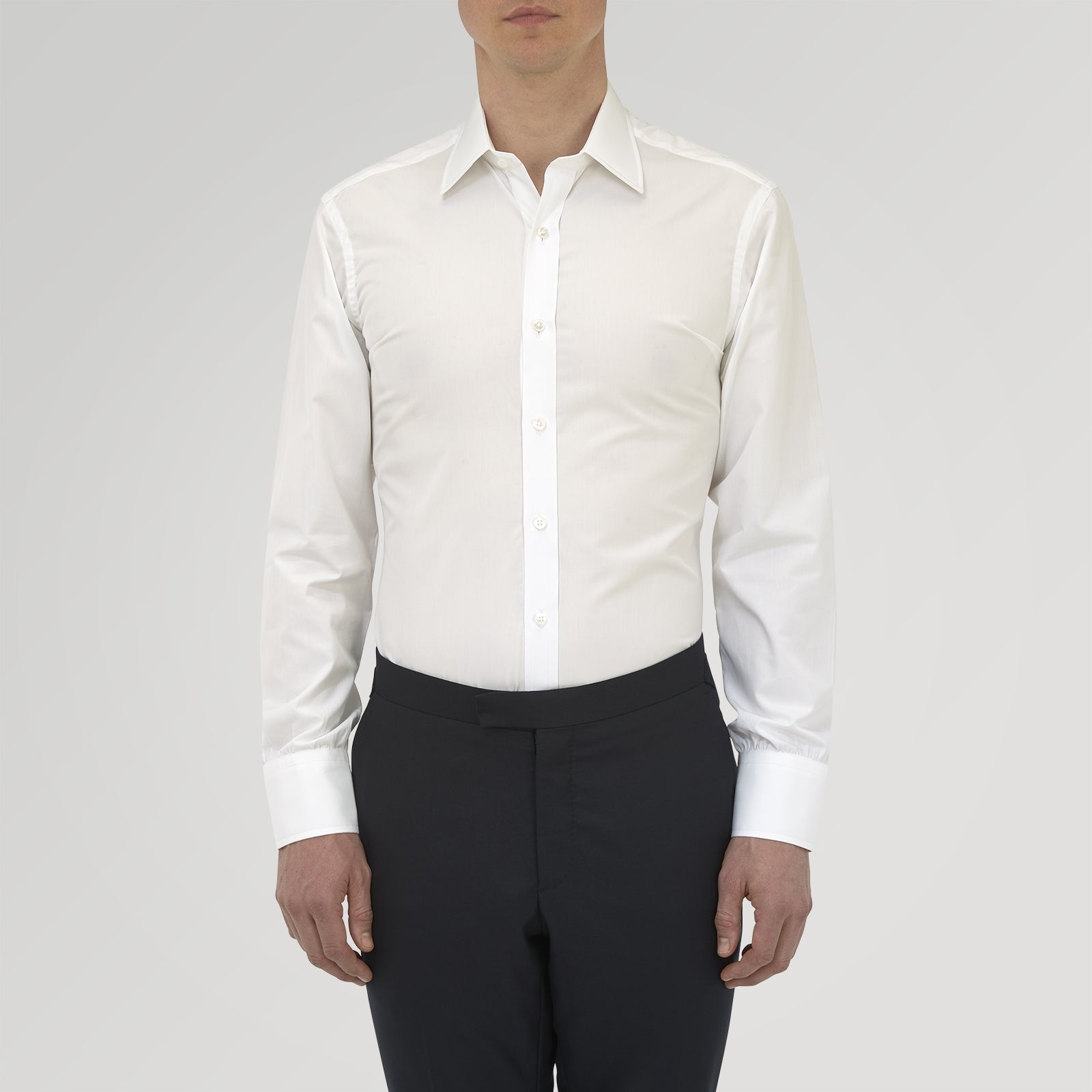 View 3 of product The Turnbull & Asser Tailored Fit Two-Fold 120 White Cotton Shirt features a Kent collar, double cuffs, and button-down front, displayed neatly folded against a light blue background.