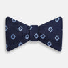View 1 of product The Navy and Sky Blue Motif Silk Bow Tie by Turnbull & Asser features a subtle ribbed texture and light blue and white geometric floral patterns—an elegant choice for formalwear.
