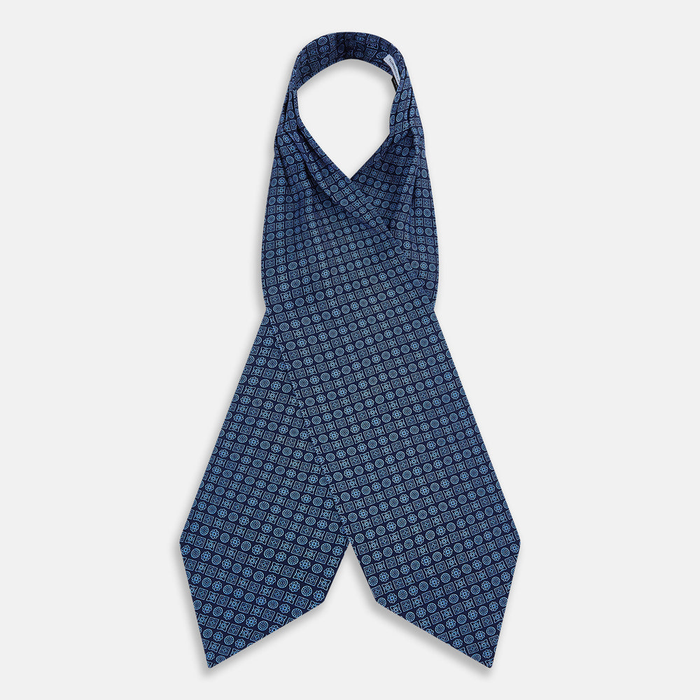 The Turnbull & Asser Dark Navy Floral Tile Pattern Printed Silk Cravat features a British-inspired light blue floral tile design, elegantly displayed on a white background.