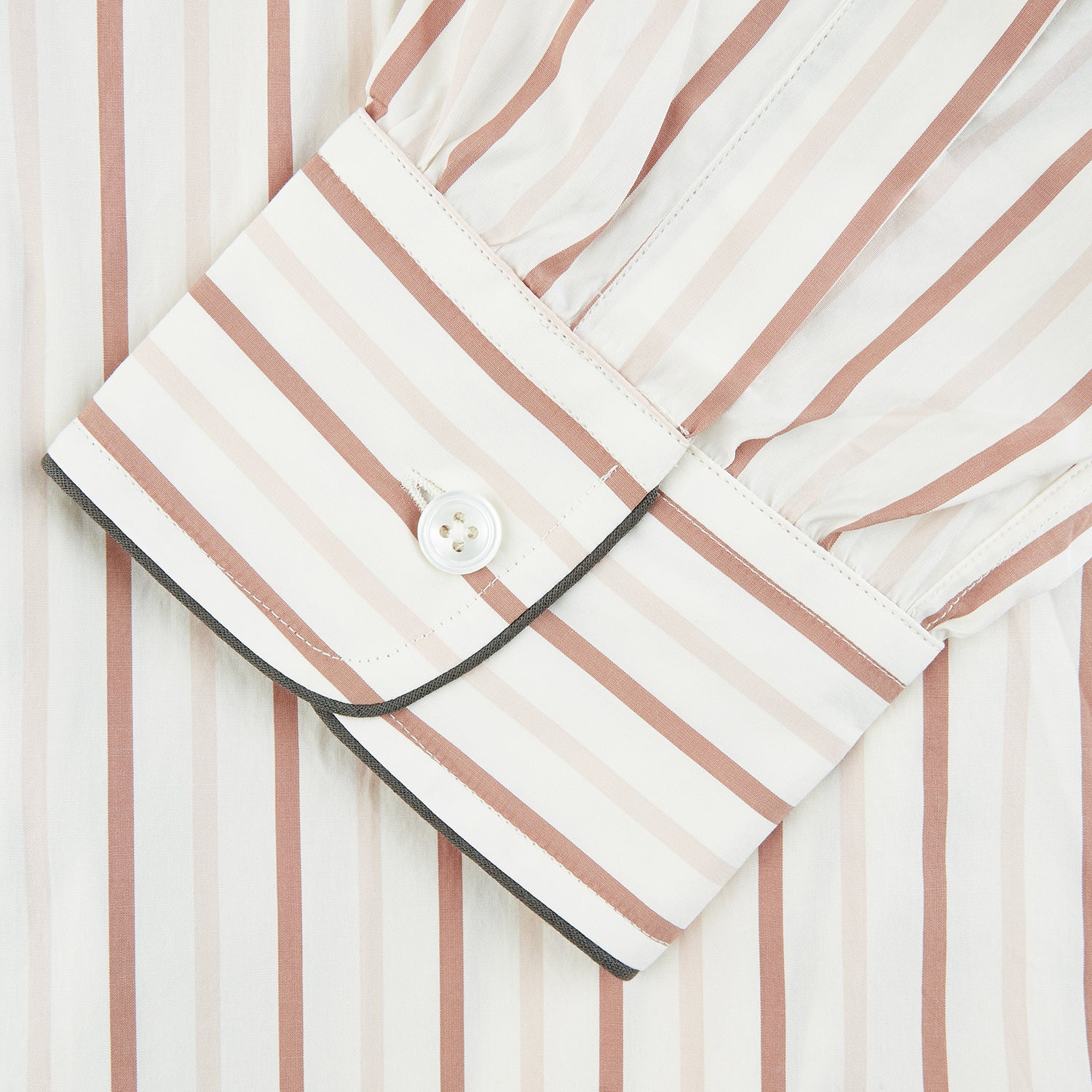 View 3 of product The Burgundy Multi Striped Cotton Sussex Nightshirt by Turnbull & Asser features long sleeves, knee length, a pointed collar, chest pocket, burgundy and beige stripes on white, buttoned cuffs, and a curved hem for classic sleepwear style.