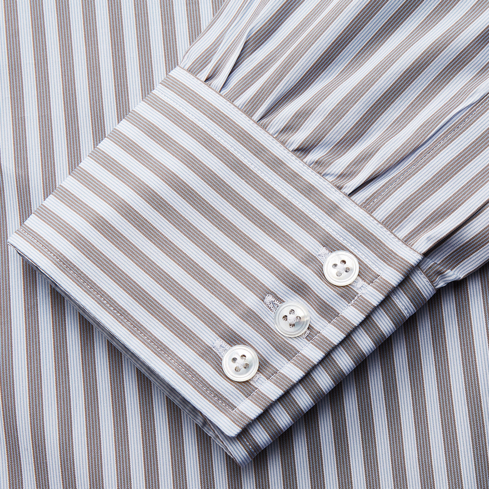 The Turnbull & Asser Pale Blue Multi Stripe Cotton Regular Fit Mayfair Shirt features long sleeves, a pointed collar, buttoned cuffs, and vertical stripes in pale blue tones, displayed against a white background.