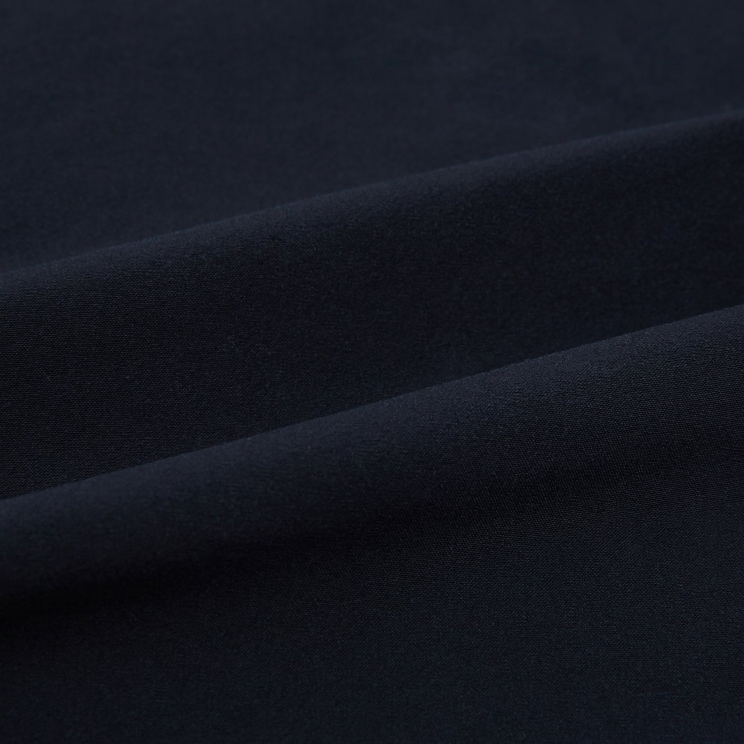View 6 of product The Midnight Blue Hyde Overshirt by Turnbull & Asser is a plain, long-sleeve shirt in dark navy sanforised cotton with a single chest pocket, spread collar, and black buttons, shown laid flat on a white background.