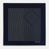 View 3 of product The Navy and White Stripe Silk Pocket Square by Turnbull & Asser features thin white vertical stripes and "TURNBULL & ASSER HAND PRINTED IN ENGLAND" in one corner, with a folded edge showing the reverse of this elegant silk accessory.