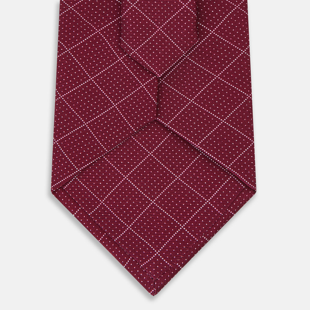 The Turnbull & Asser Burgundy Dotted Check Pattern Printed Silk Tie is shown rolled up on a plain white background.