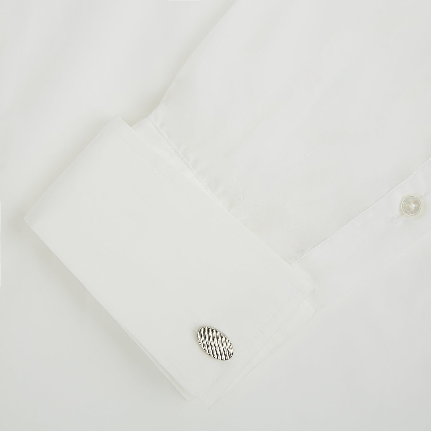 View 3 of product Turnbull & Asser Silver Striped Oval Cufflinks feature a classic diagonal pattern on a silver oval face, displayed against a plain white background.