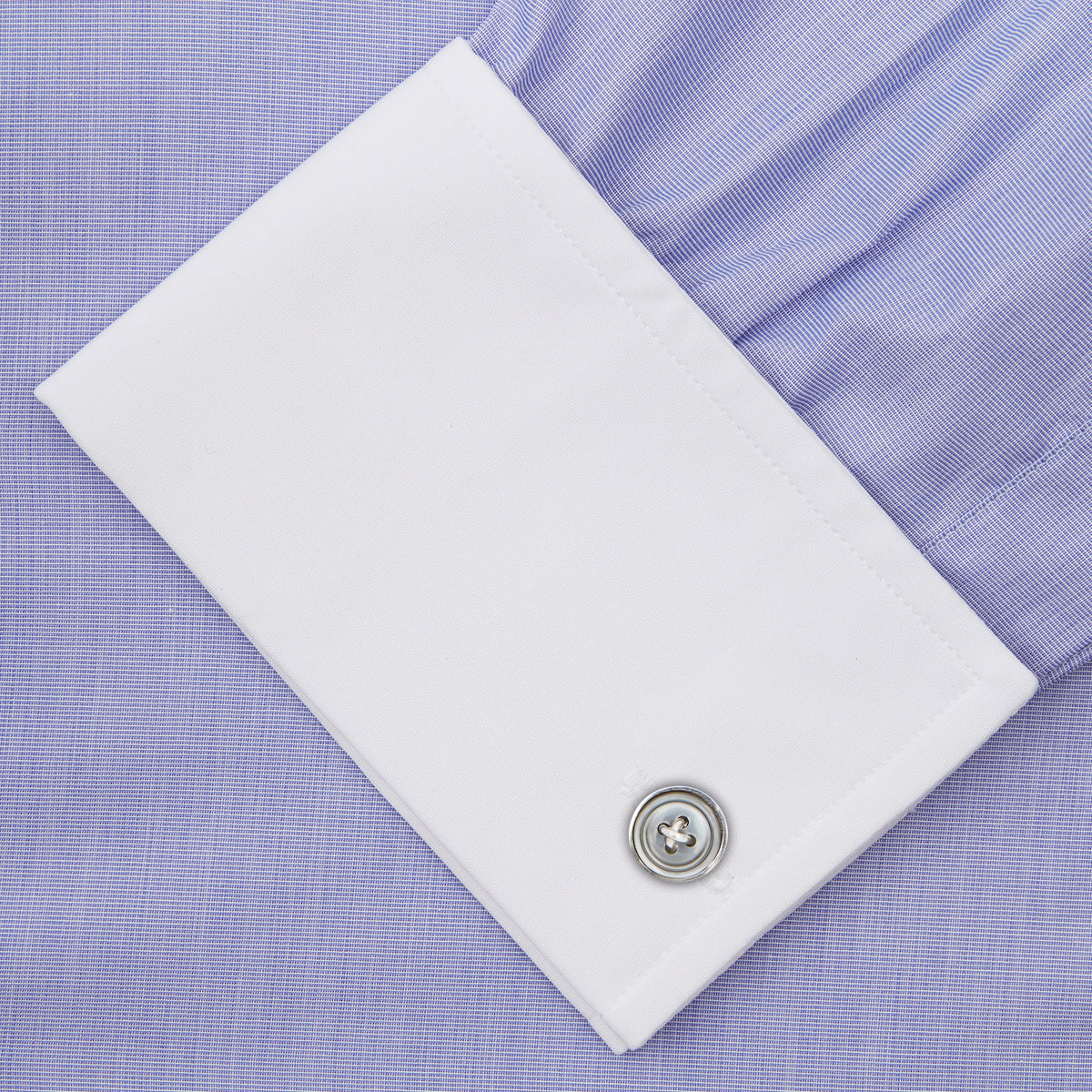 View 6 of product The Wall Street Shirt with White T&A Collar by Turnbull & Asser, as seen on Gordon Gekko, is folded neatly to showcase its light purple color, crisp French cuffs, and iconic contrasting collar against a plain background.