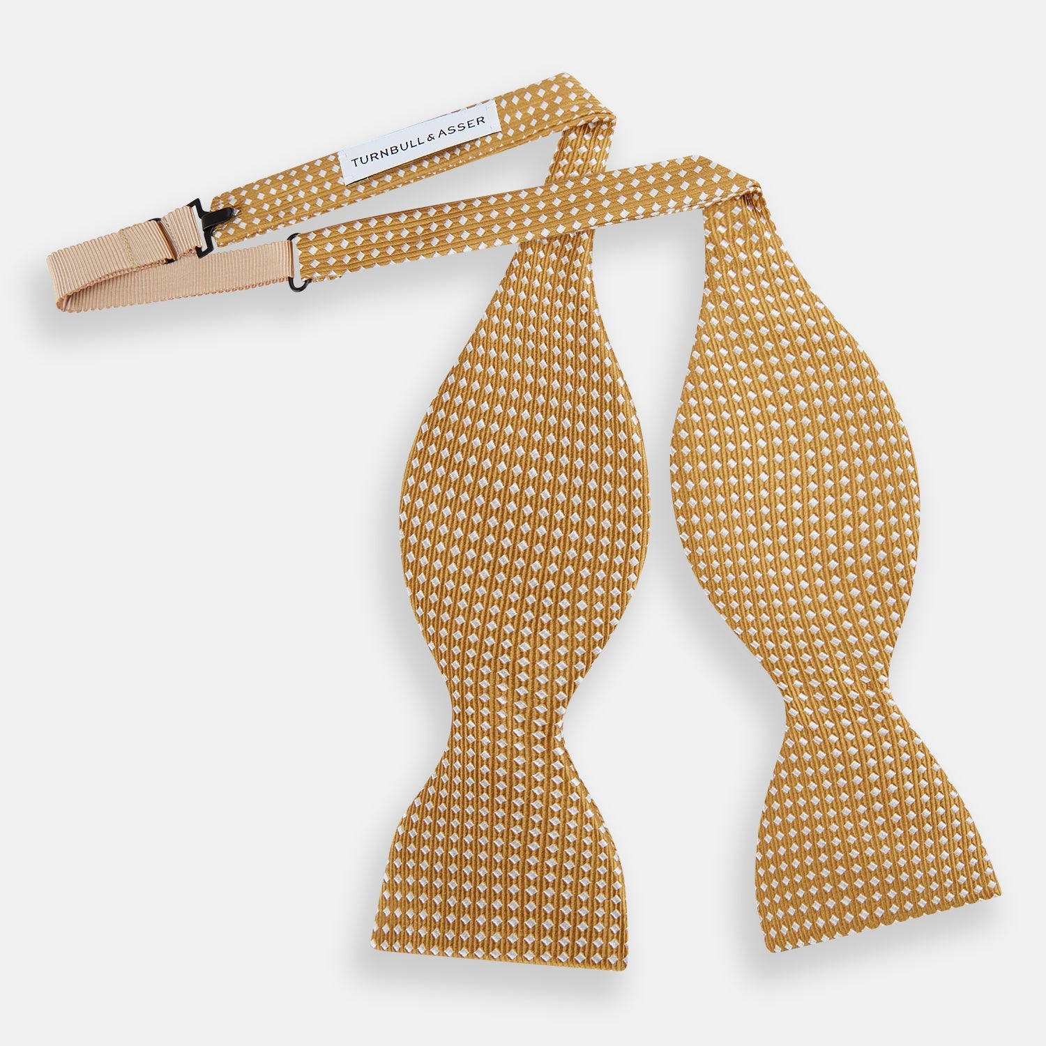 View 2 of product The Turnbull & Asser Camel and White Diamond Silk Bow Tie features a ribbed texture with evenly spaced white diamond shapes, offering an elegant accessory for formalwear, shown on a white background.