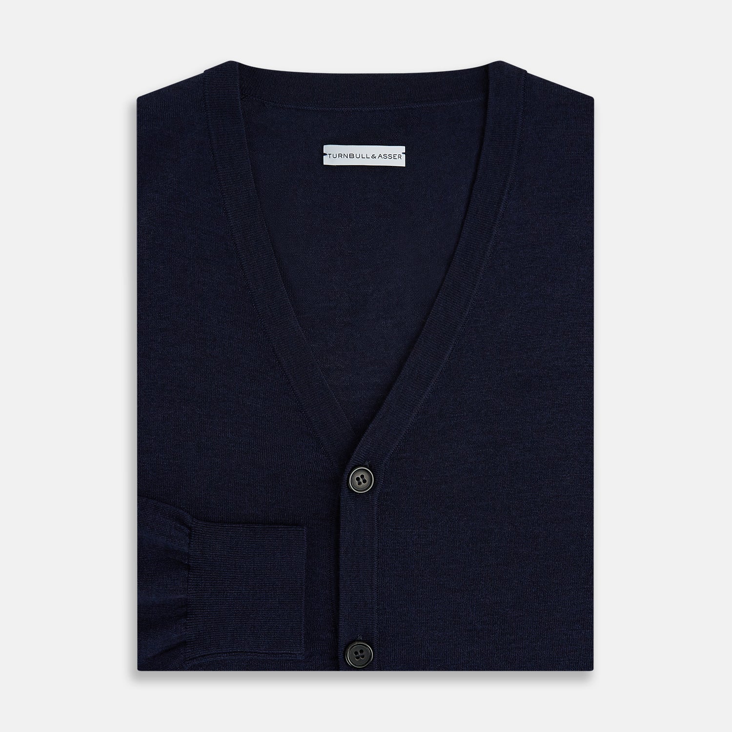 View 4 of product The Turnbull & Asser Navy Fine Merino V-Neck Cardigan features long sleeves, ribbed cuffs and hem, and is crafted from premium yarn for comfort and style, shown on a white background.