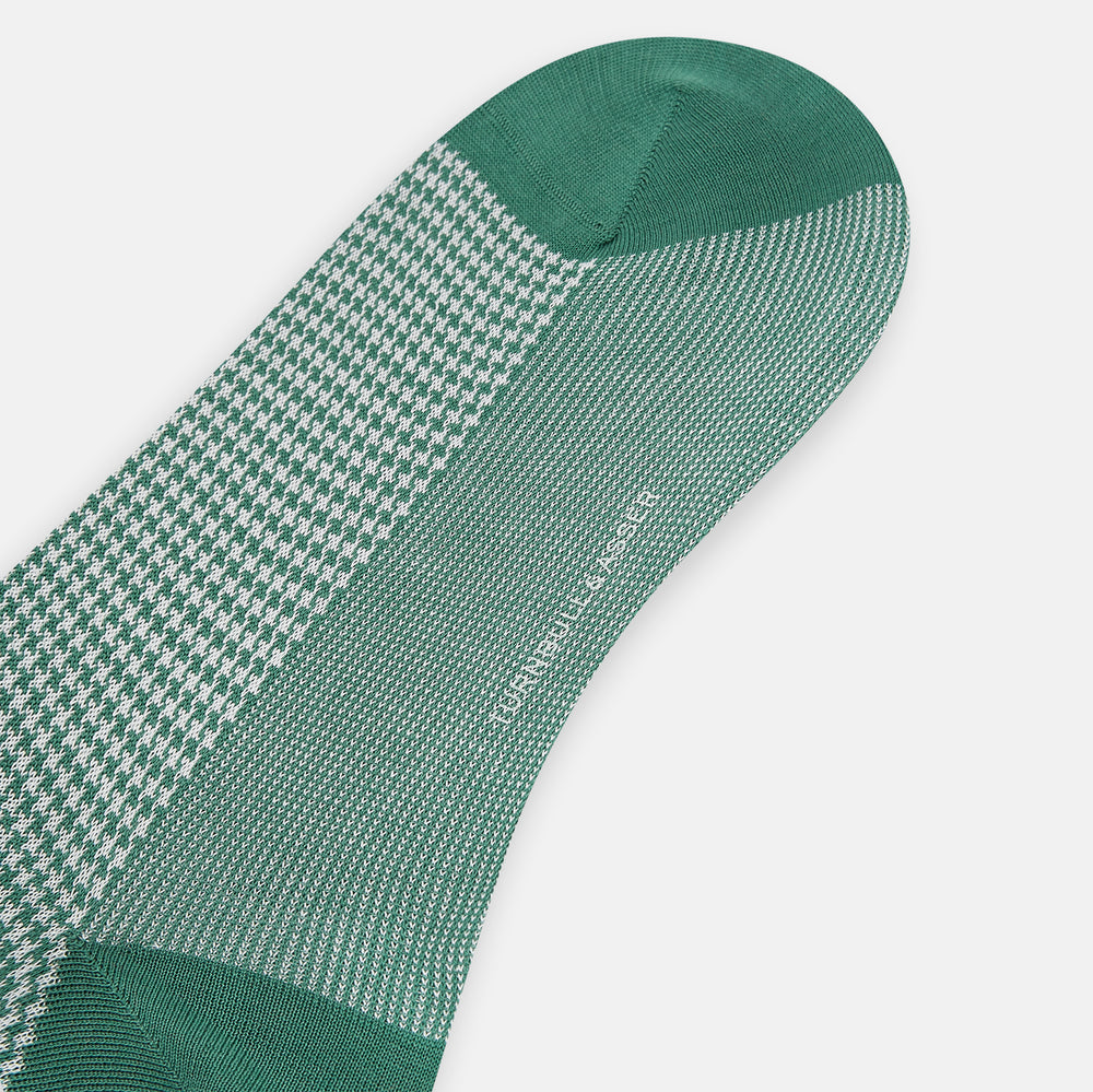The Ivory/green Houndstooth Long Sock by Turnbull & Asser features a houndstooth pattern on the lower half with a solid green upper band, heel, and toe, shown against a white background.