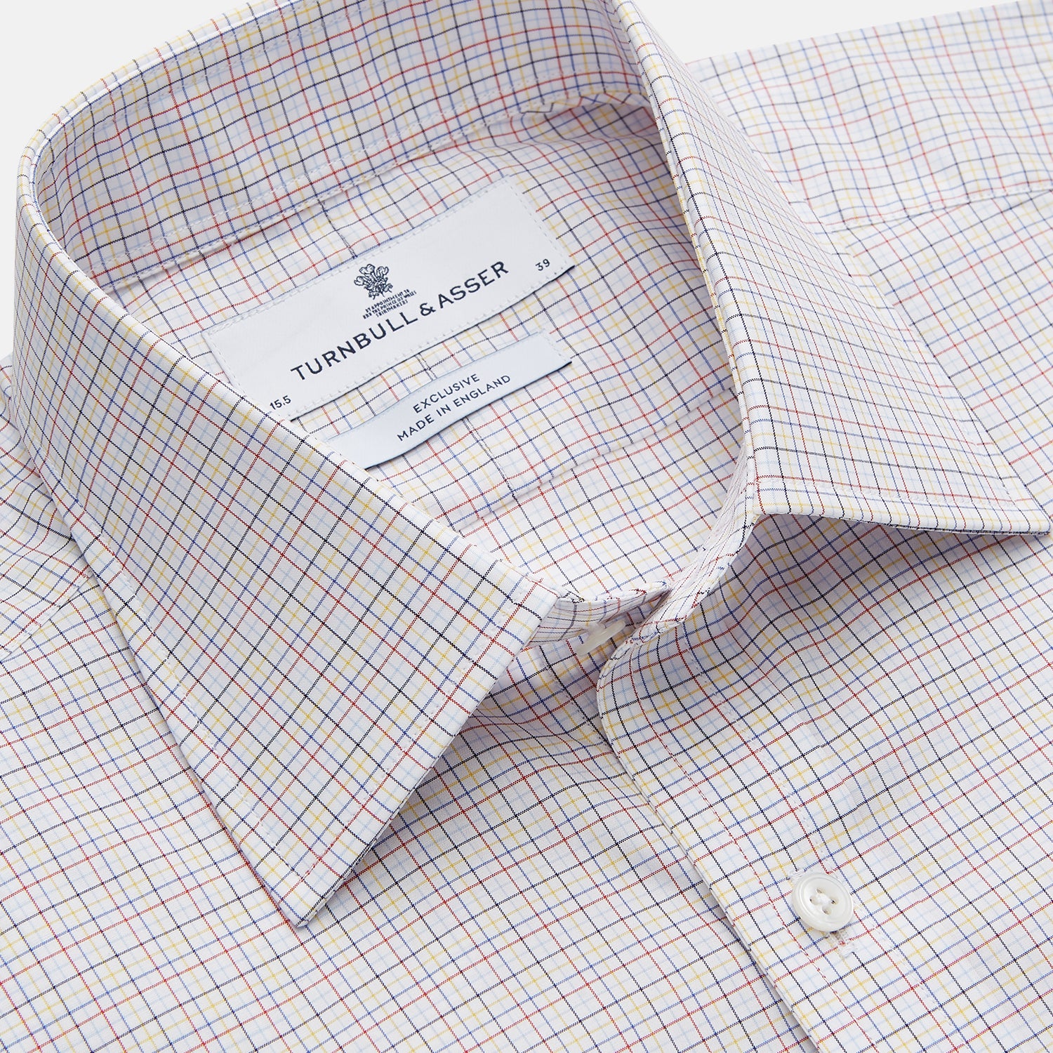 View 3 of product A man stands against a beige background, facing forward with a neutral expression and arms relaxed, wearing the Turnbull & Asser Red Multi Check Regular Fit Mayfair Shirt.