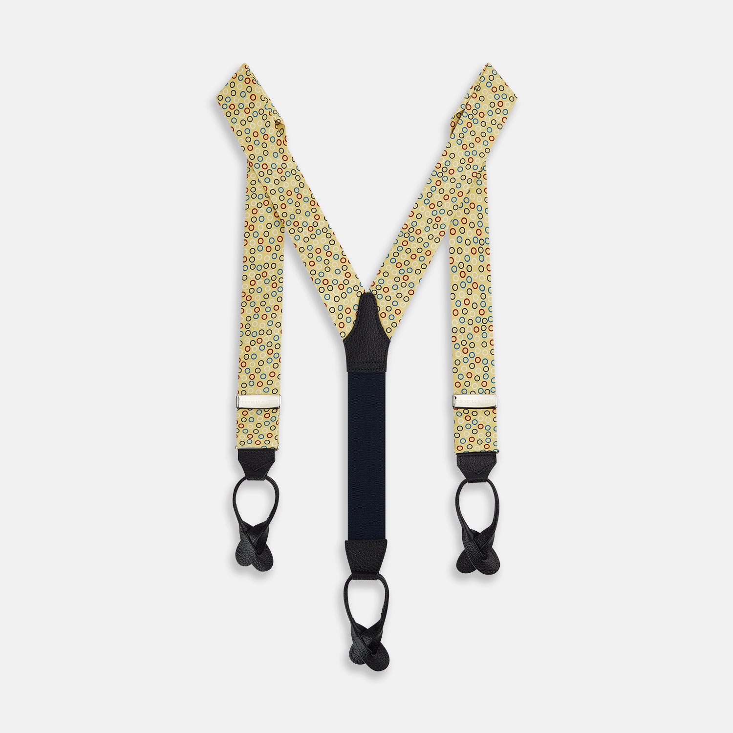 View 1 of product Turnbull & Asser Multi-coloured Circle Yellow Adjustable Silk and Navy Leather Braces, featuring gold-toned metal clips, bring refined style to any outfit. Shown laid flat on a white background.